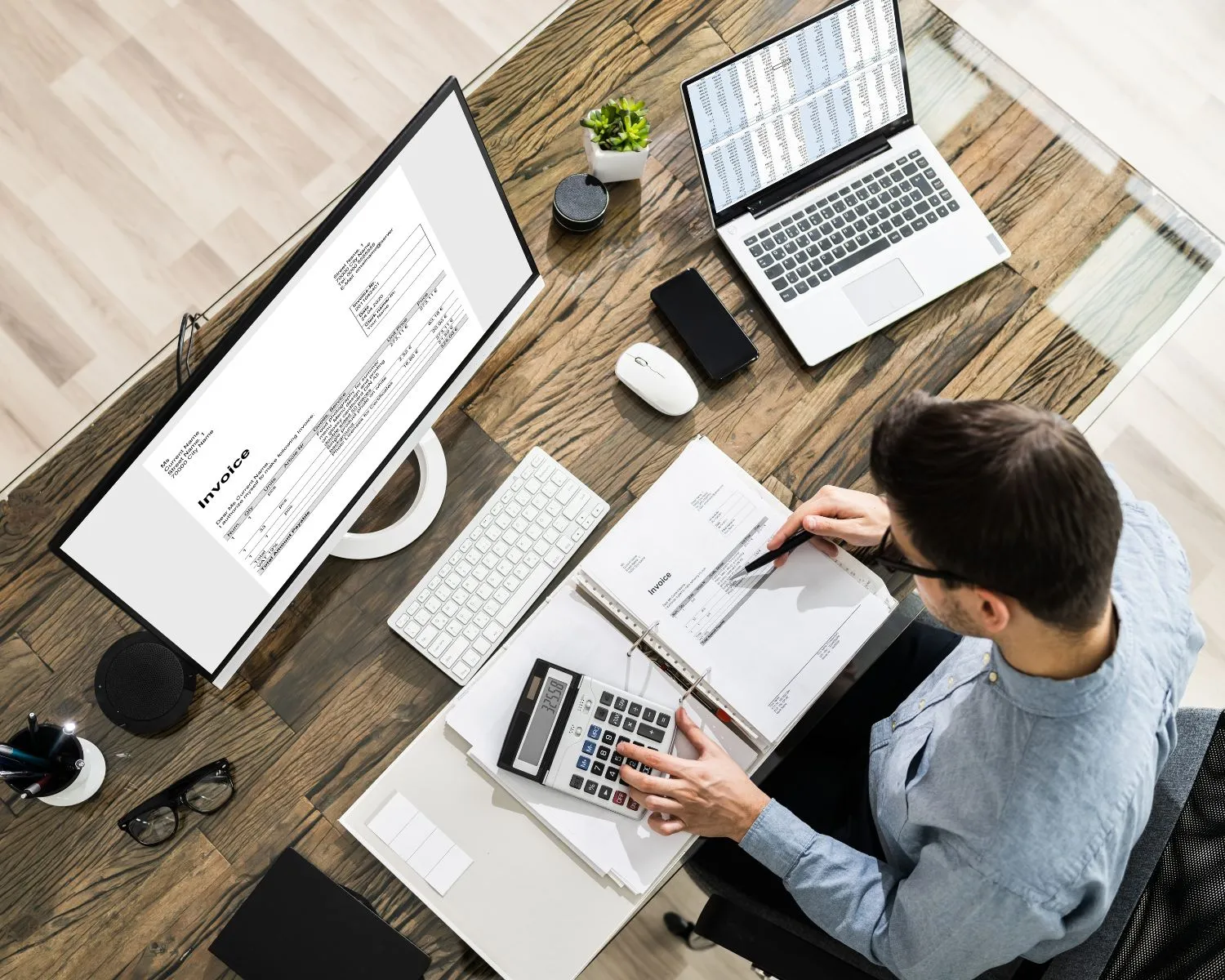 Accountant sitting at his desk with computer laptop and documents.